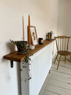 a shelf with some plants and pictures on it