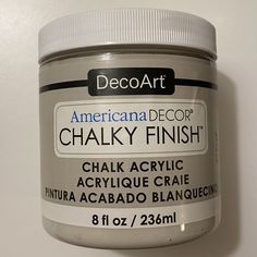 a jar of chalk paint sitting on top of a white counter next to a wall