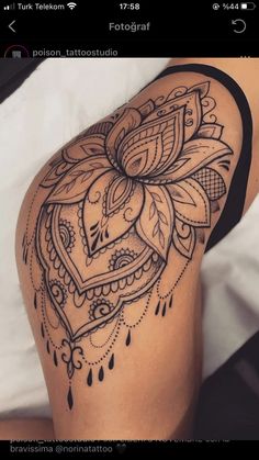 a woman's thigh with an intricate tattoo design on it