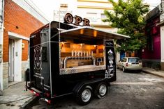 a food truck is parked on the side of the road in front of a building