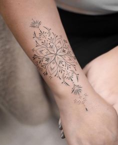 a woman's arm with a tattoo design on the left side of her arm