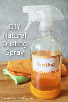 a bottle of disinfectant sitting on top of a wooden table next to an orange towel