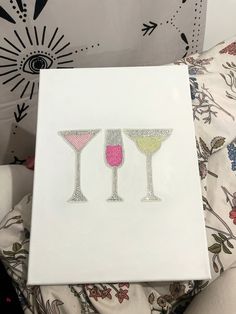 three martini glasses with pink, yellow and green in them on top of a white canvas