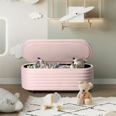 a pink toy chest sitting on top of a wooden floor next to a teddy bear