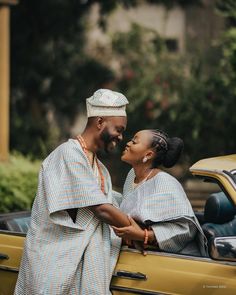 two people standing next to each other near a car