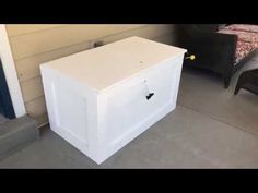 a white box sitting on the ground next to a chair