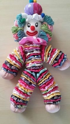 a multicolored clown doll laying on top of a table