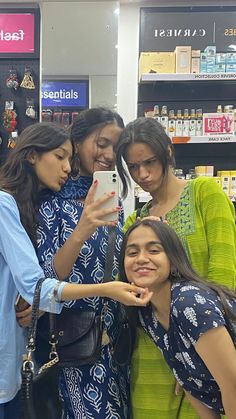 three women taking a selfie in a store with one woman holding a cell phone