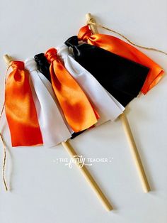 three orange, white and black candy sticks tied together