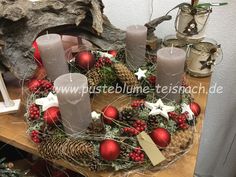 a christmas wreath with candles and decorations on a table