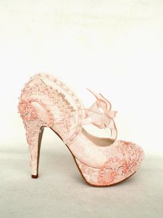 a pink high heeled shoe with an intricate lace design on the front and side