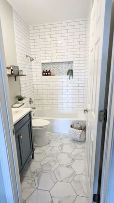 a bathroom with white tile and gray cabinets