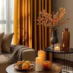 a living room filled with furniture and a table topped with fruit next to a window