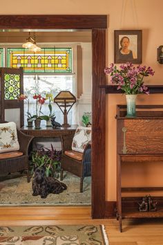 a dog laying on the floor in front of a mirror with stained glass behind it