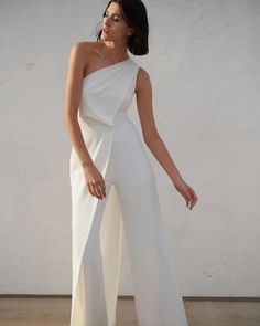 a woman wearing a white jumpsuit with one shoulder and an asymmetrical top