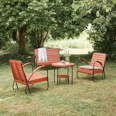 three chairs and a table in the grass