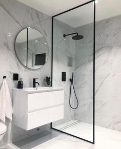 a white bathroom with marble walls and floor