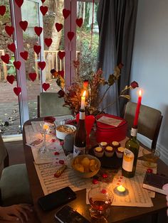 the table is set with wine, snacks and candles for valentine's day dinner