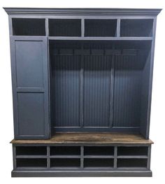 a large gray bookcase with wooden shelves and doors