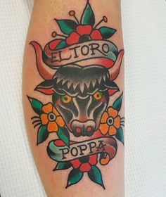 a tattoo on the leg of a person with an animal head and ribbon around it