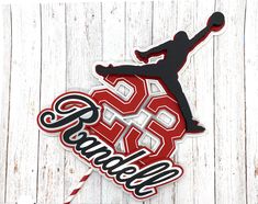 a cake topper with the word cheer on it and a basketball player jumping up in the air