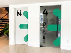 two doors with green and white stickers on them in an office building lobby area