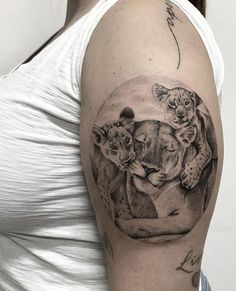 a woman with a tattoo on her arm has a drawing of two lions and a leopard