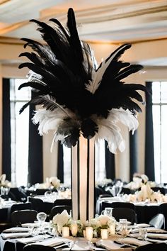 the centerpiece is decorated with black and white feathers