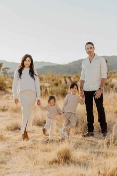 a family standing in the desert holding hands