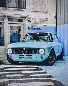 a blue car parked in front of a building