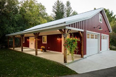 a red and white garage sitting in the middle of a lush green field