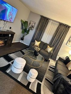 a living room filled with furniture and a flat screen tv mounted on the wall over a fireplace