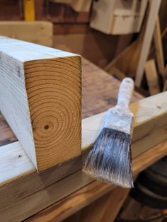 a paintbrush sitting on top of a piece of wood