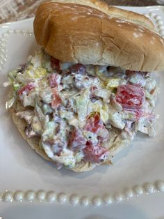 a sandwich is sitting on a plate with some sort of salad in the middle of it