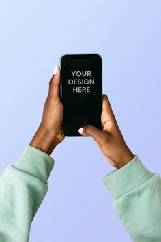 two hands holding up an electronic device with the text your design here on it in front of a blue background