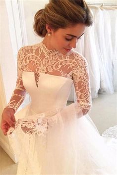 a woman in a white wedding dress looking down