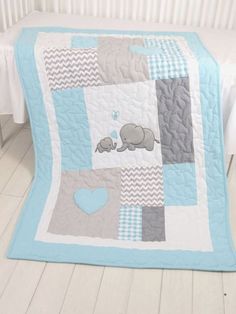 a blue and gray baby quilt with an elephant on it