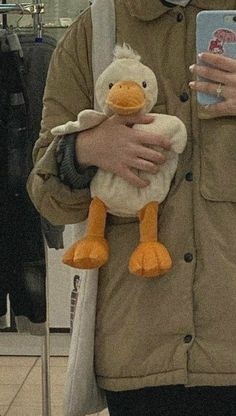 a person holding a stuffed duck in their arms