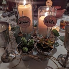 candles and succulents are arranged on a table with place cards for the bride