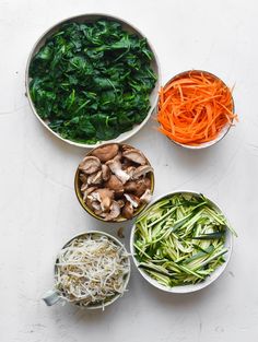 bowls filled with different types of vegetables on top of a white countertop next to each other