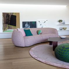 a living room filled with furniture on top of hard wood flooring next to white walls