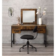 a desk with a mirror and chair in front of it on a wooden floor next to a wall