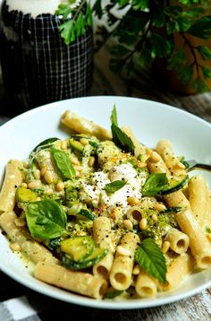 a white plate topped with pasta and vegetables