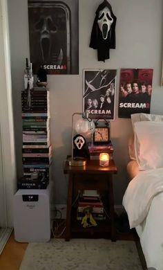 a bed room with a neatly made bed next to a night stand and posters on the wall