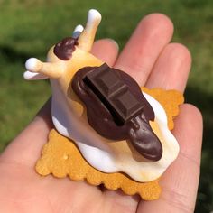 a hand holding a small toy with chocolate on it