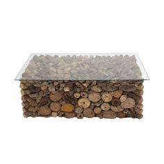 a glass table topped with lots of wood and rocks on top of a white background