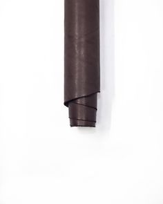 a roll of brown paper sitting on top of a white wall