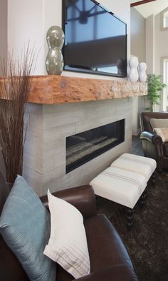 a living room with couches and a flat screen tv on the wall above a fireplace