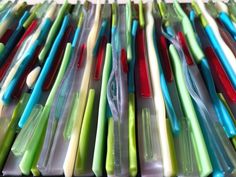 many different colored toothbrushes in plastic containers