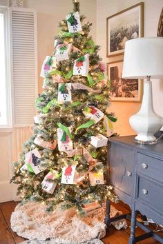 a decorated christmas tree in the corner of a room with pictures on the wall behind it